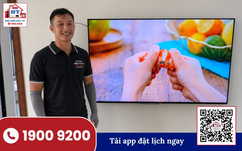 Kiểm tra tivi tại nhà Kỹ thuật viên đang kiểm tra màn hình tivi đặt trên bàn, phía sau là tường trắng và cửa sổ.