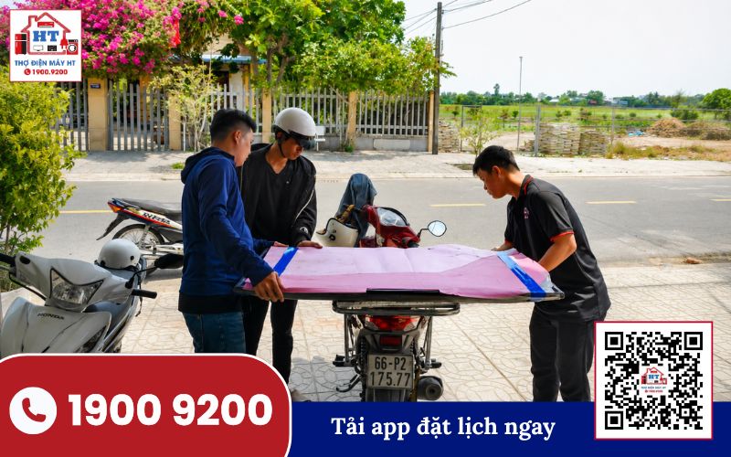 Vận chuyển tivi an toàn đến địa điểm của khách hàng Người đàn ông mặc áo xanh vận chuyển tivi màn hình phẳng màu đen đến nhà khách hàng