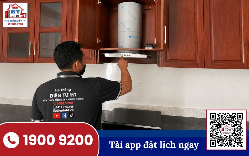 Kiểm tra và bảo dưỡng máy hút mùi định kỳ Hình ảnh kỹ thuật viên đang kiểm tra hoặc sửa chữa máy hút mùi gắn tường trong không gian bếp gia đình