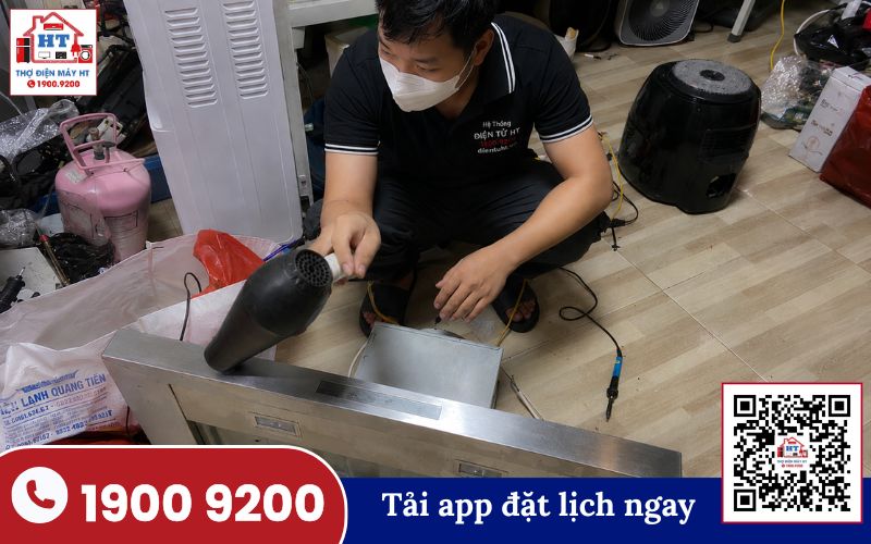 Kiểm tra động cơ và quạt máy hút mùi Kỹ thuật viên đang kiểm tra bên trong máy hút mùi, tập trung vào khu vực động cơ và hệ thống quạt